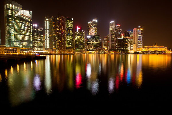 A view of Singapore business district Marina Bay, in the night time, with water reflections.