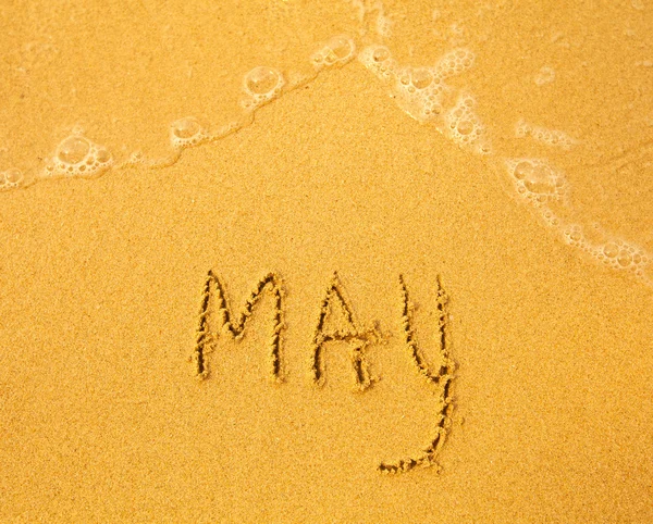 Maj - skriven i sanden på stranden konsistens — Stockfoto