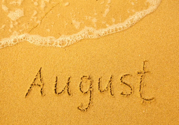 August - in Sand auf Strand-Textur geschrieben — Stockfoto