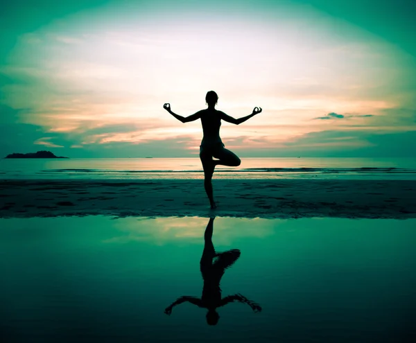Silhouet van een vrouw mooi yoga bij zonsondergang (in surrealistische kleuren) — Stockfoto