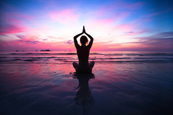 Zonsondergang yoga vrouw op zee kust — Stockfoto