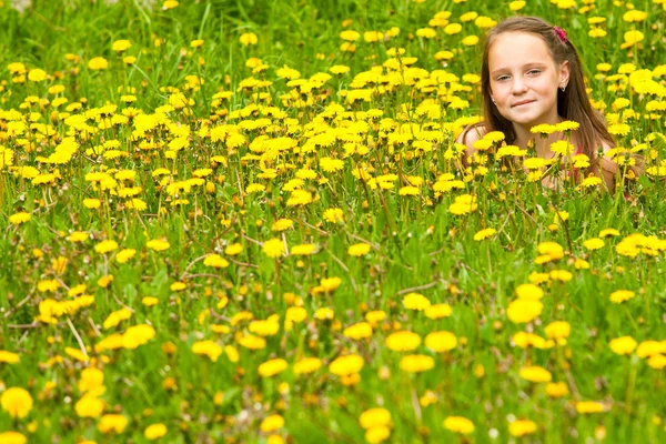 Klein meisje liggen in gras. — Stockfoto