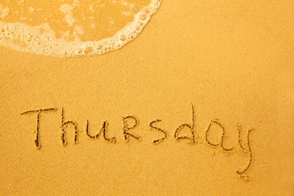 Thursday - written in sand on beach texture - soft wave of the sea (days week series) — Stock Photo, Image