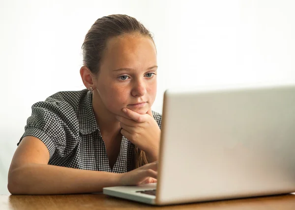 Portret van een jong meisje, die op laptop werkt. — Stockfoto