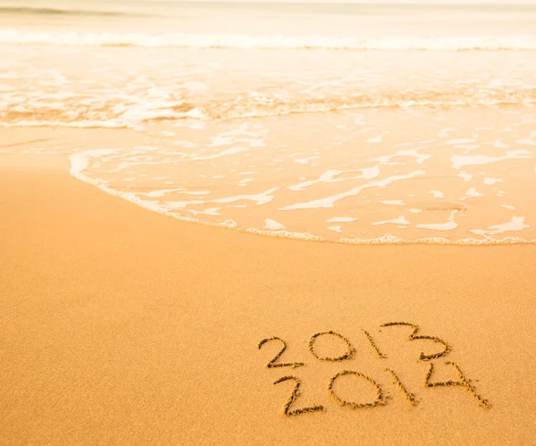 2013 - 2014 written in sand on beach texture - soft wave of the sea. — Stock Photo, Image
