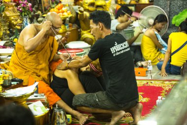 Tanımlanamayan keşiş yantra dövme yapar