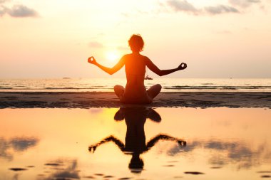 Lotus poz sahilde oturup yoga kadın