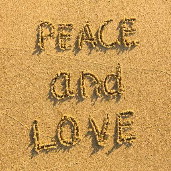 Мир и любовь - нарисованные на песке — стоковое фото