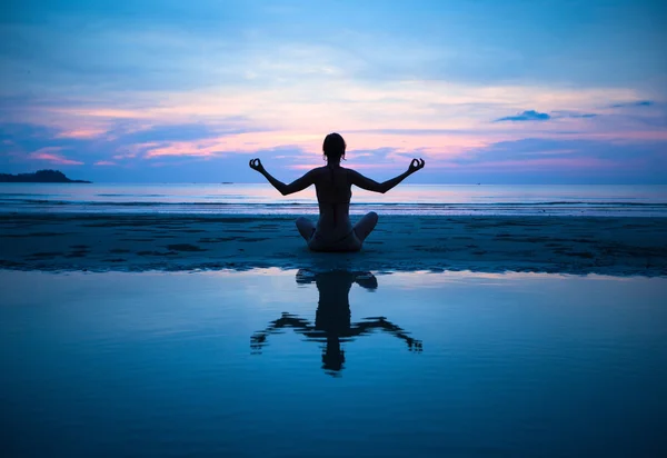 Frau praktiziert Yoga am Strand — Stockfoto