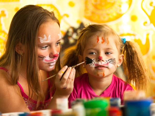 Jovens irmãs engraçadas brincando com pintura — Fotografia de Stock