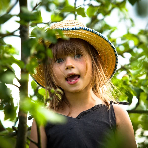 Niña posando en un sombrero de paja en el parque — Foto de Stock