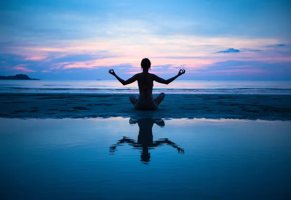 Vrouw oefenen yoga op het strand Rechtenvrije Stockafbeeldingen