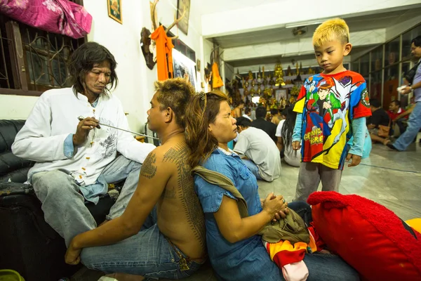 Monje no identificado hace tatuajes tradicionales Yantra durante la Ceremonia del Día del Maestro Wai Kroo en Wat Bang Pra en Nakhon Chai, Tailandia . — Foto de Stock