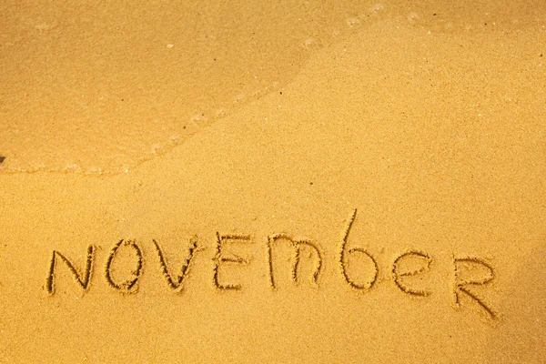 November - geschrieben in Sand auf Strand Textur — Stockfoto