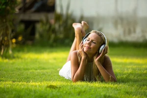 Дівчина з навушниками насолоджується природою і музикою — стокове фото
