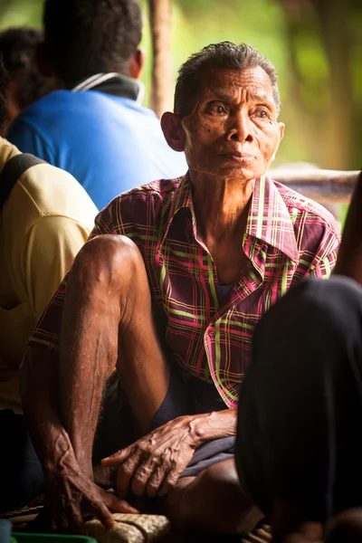 BERDUT, MALASIA - 8 DE ABR: Mujer no identificada Orang Asli trilla arroz para eliminar la paja el 8 de abril de 2013 en Berdut, Malasia . — Foto de Stock
