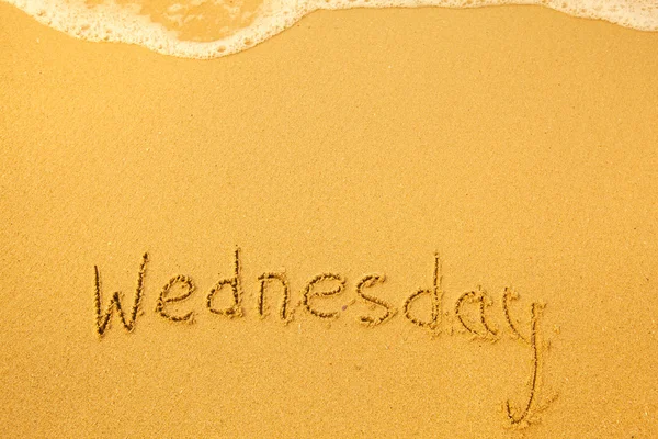 Wednesday - written in sand on beach texture — Stock Photo, Image