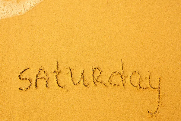 Sábado - escrito em areia na textura da praia — Fotografia de Stock