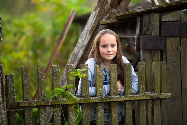 Teen flicka står nära vintage lantlig staket — Stockfoto