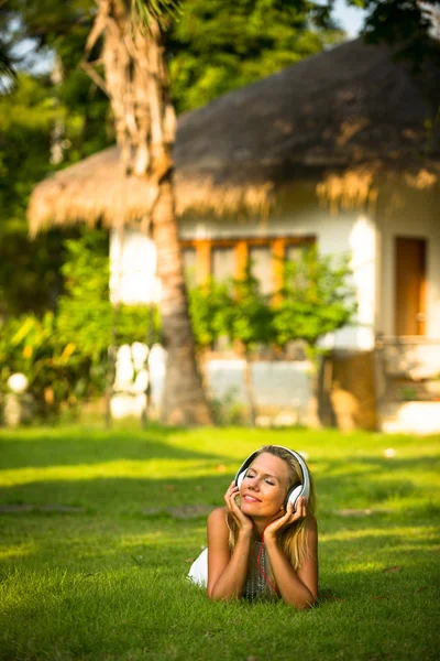 Красива дівчина з навушниками насолоджується природою і музикою в сонячний день — стокове фото
