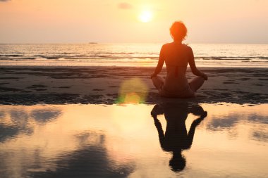 Yoga kadın bir plajda