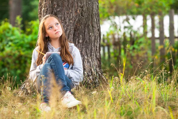 Tienermeisje met notebook in park Rechtenvrije Stockfoto's