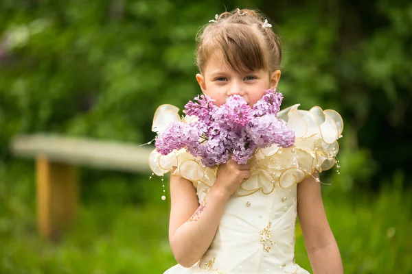 ライラック屋外の花束を持つ少女の肖像画 — ストック写真