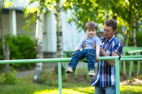 Far och son på lekplatsen — Stockfoto