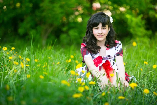 Mooie teengirl zitten in het gras — Stockfoto