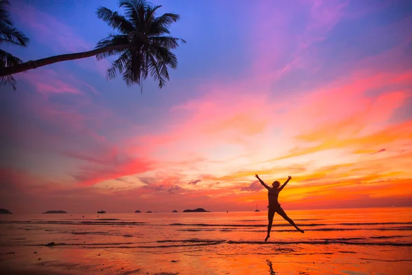 Junges Mädchen bei einem Sprung am Strand bei Sonnenuntergang (Konzept des lang ersehnten Urlaubs)) — Stockfoto