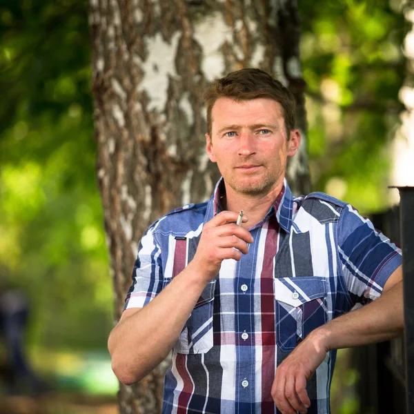 Muž kouření v parku. — Stock fotografie