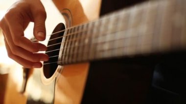 Yakın plan: parmaklar gitarın tellerine dokunur