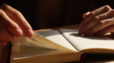 Kadınların elleri bir kitap aracılığıyla leafing