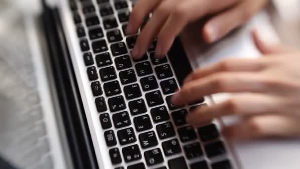 Gros plan d'une jeune femme tapant sur un clavier d'ordinateur portable