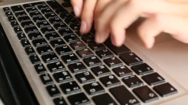 Primer plano de una joven escribiendo en un teclado portátil — Vídeos de Stock