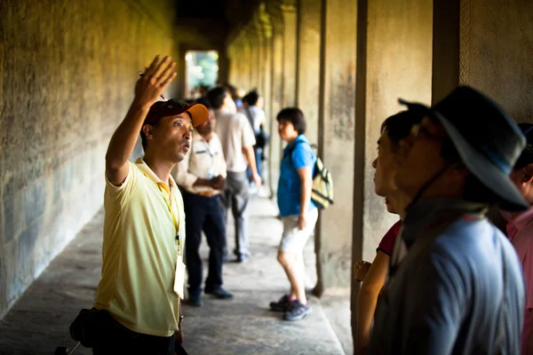 Siem reap, Kambodscha - 13. Dezember: ein unbekannter kambodschanischer Fremdenführer führt einen Touristen in angkor wat, 13. Dezember 2012 auf siem reap, Kambodscha. angkor ist die Hauptattraktion des Landes für Besucher. — Stockfoto