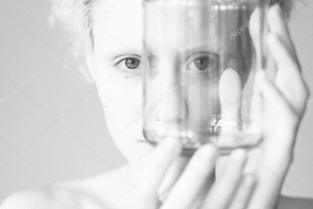 Abstract picture - the girl looks through the empty jar (black and white photo)