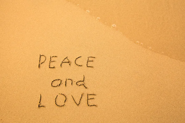 Pesce and Love - text written by hand in sand on a beach, with a blue wave. — Stock Photo, Image