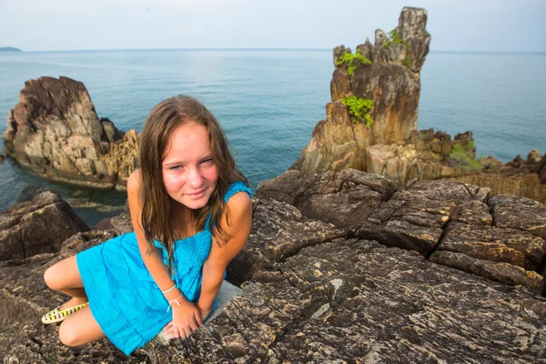 Teengirl w niebieską sukienkę w skałach wybrzeża. — Zdjęcie stockowe