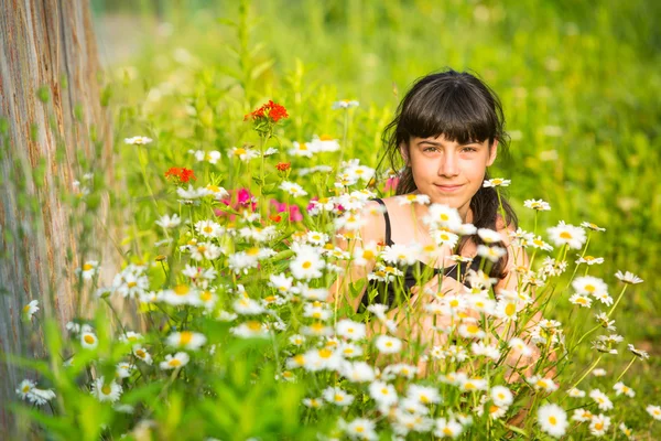 Retrato de niña entre flores silvestres. Imagen de stock