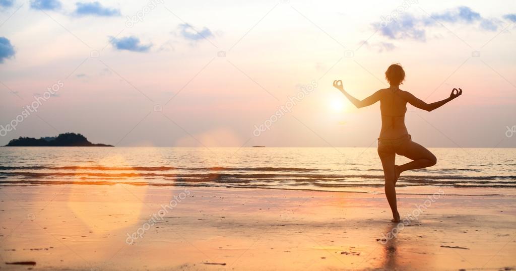 Yoga woman on the beach during sunset (in bright colors)