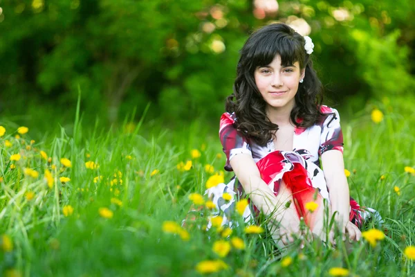 Een tiener meisje zit in het gras — Stockfoto