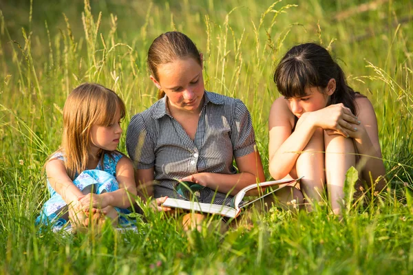 Crianças lendo livro no parque juntos . — Fotografia de Stock