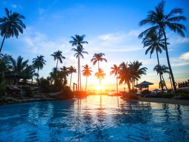 Beautiful sunset at a beach resort in tropics clipart