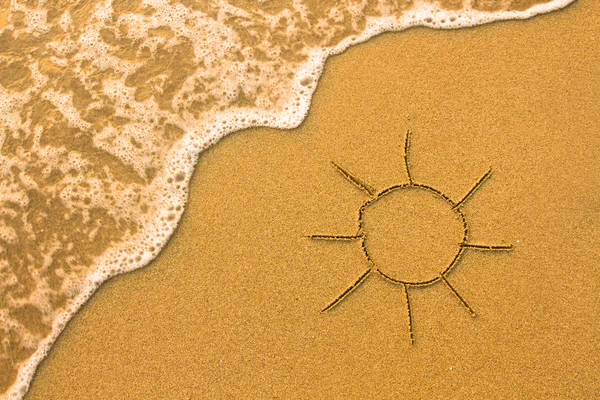 Солнце, нарисованное на песке пляжа . — стоковое фото