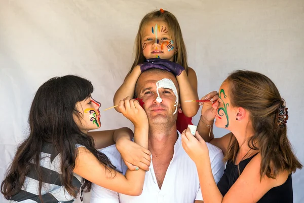 Barn målar ansiktet av sin far (glad familj koncept) — Stockfoto