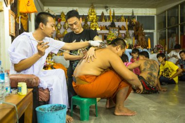 Tanımlanamayan keşiş geleneksel yantra günü töreni sırasında wai kroo master dövme yapar