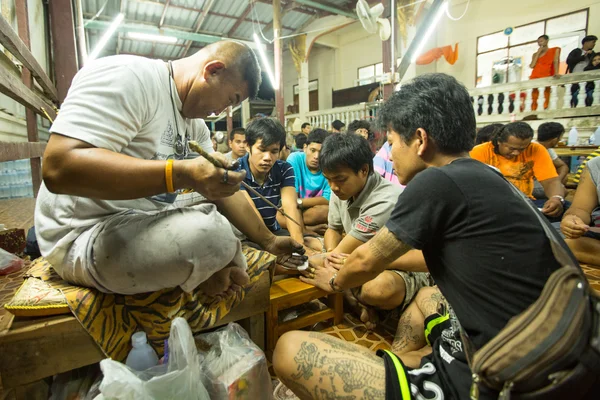 Tanımlanamayan keşiş geleneksel yantra günü töreni sırasında wai kroo master dövme yapar