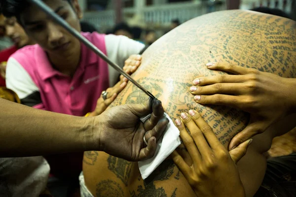 Unbekannter Mönch tätowiert traditionelle Yantra-Tätowierung während der wai kroo Meisterfeier — Stockfoto