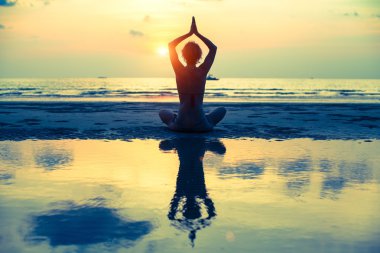 Lotus poz sahilde oturup yoga kadın